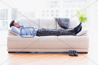 Tired businessman sleeping on a sofa