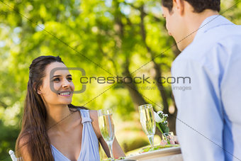 Couple with champagne flutes sitting at an outdoor café