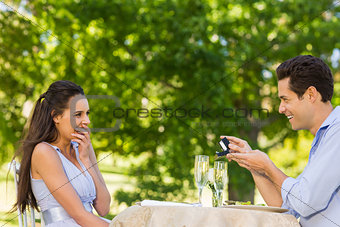 Man proposing woman at an outdoor café