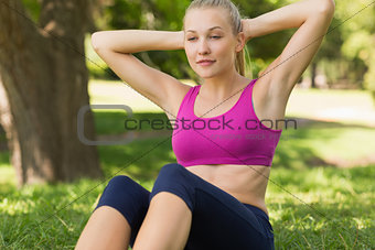 Healthy and beautiful woman doing stomach crunches in park