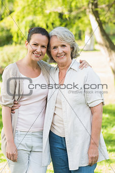 Portrait of smiling woman with adult daughter at park