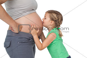Little girl kissing her mothers baby bump