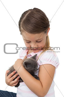 Cute girl cuddling grey kitten