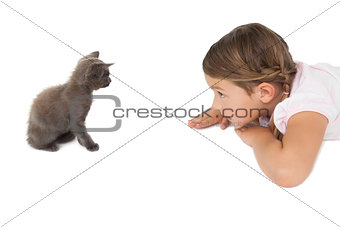 Little girl looking at grey kitten sitting on floor