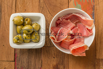 Typical Spanish tapas: serrano ham and green olives