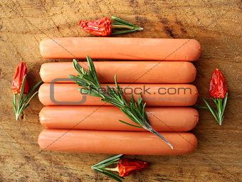 Fresh sausages on the wooden background