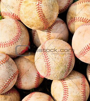 closeup of pile up a stack of old baseball in green