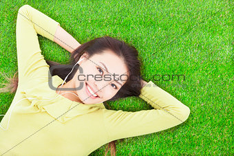 beautiful  woman holding head and lying on a meadow