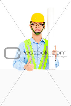 Happy  architect holding  blueprints and thumb up