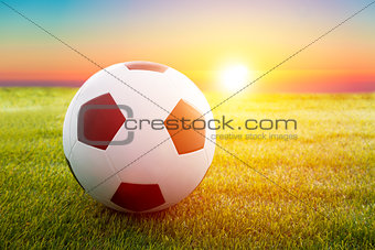 soccer ball on the field with sunset 