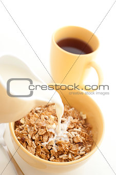 Pouring milk into breakfast cereal - high key