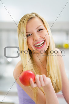 Portrait of smiling young woman with apple