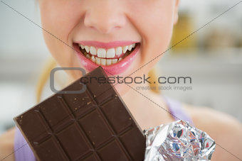 Closeup on young woman eating chocolate