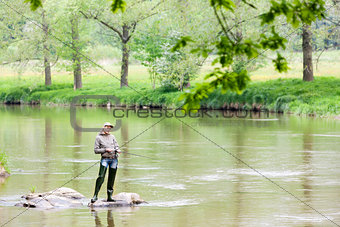 woman fishing in Sazava river, Czech Republic