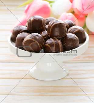 chocolate candy and flowers on wooden background