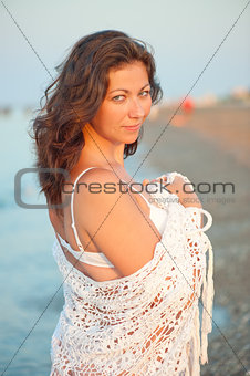 portrait of charming brunette in a white shawl at dawn