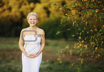 beautiful pregnant young woman in greek white dress outside