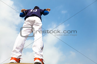  baseball player holding a bat with cloud background