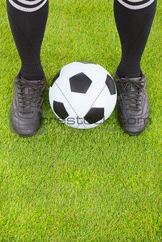 Soccer player's feet  and football on field 