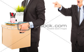 An angry boss firing a man and carrying belongings