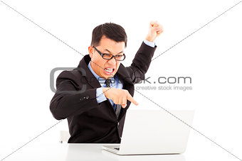  businessman yelling and make a fist with laptop