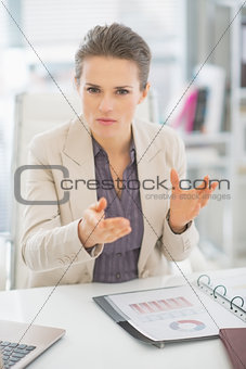 Portrait of business woman in office explaining something