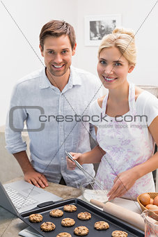Portrait of young couple preparing cookies in kitchen
