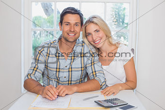 Couple with financial documents and calculator at home