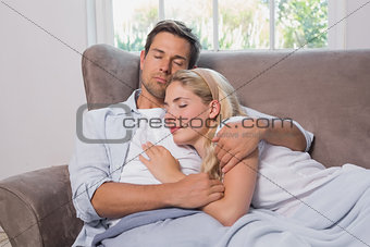 Loving young couple sleeping together on sofa