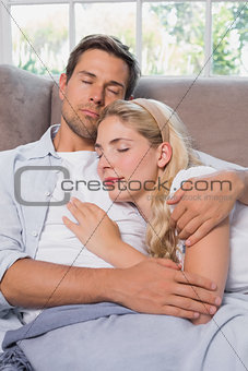 Relaxed loving couple sleeping together on sofa