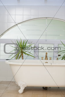 Contemporary bathroom interior with tub and tiled wall