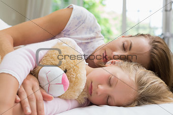 Girl and mother sleeping peacefully with stuffed toy
