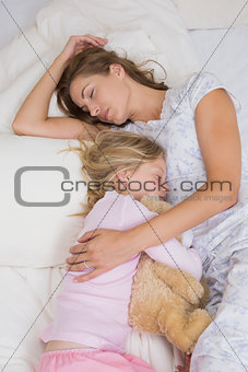 Girl and mother sleeping peacefully with stuffed toy in bed