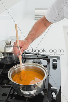 Close-up detail of a man preparing food in kitchen