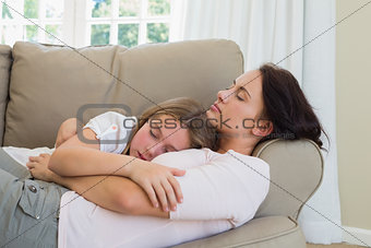 Mother and daughter sleeping on sofa