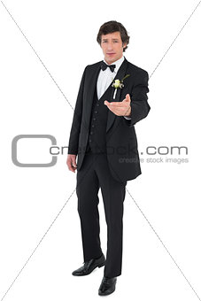 Groom in tuxedo offering hand