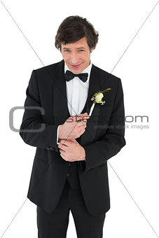 Smiling groom in tuxedo getting ready