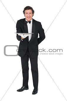 Portrait of waiter holding tray over white background