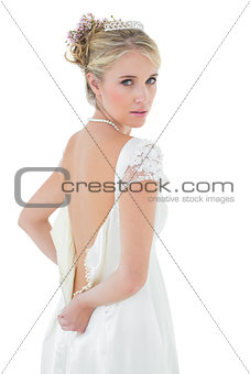 Beautiful bride getting dressed over white background