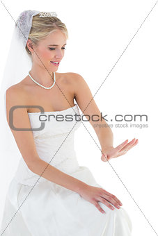Bride looking at wedding ring over white background