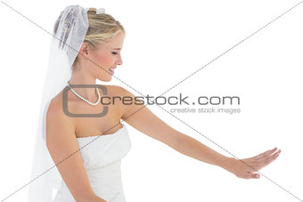 Beautiful bride looking at wedding ring over white background