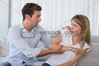 Young man consoling a sad woman in living room