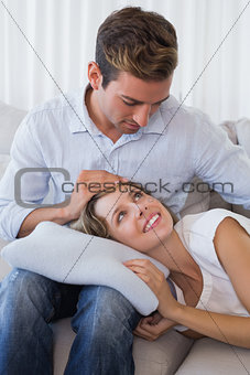 Woman resting on mans lap on couch