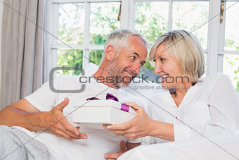 Woman giving mature man a gift box