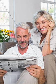 Mature couple reading newspaper