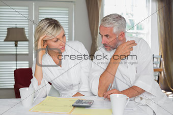 Couple sitting with home bills and calculator