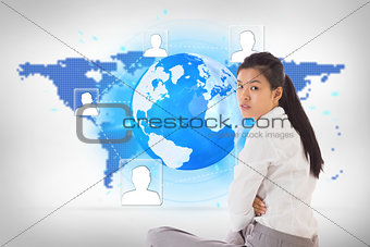 Composite image of businesswoman sitting cross legged frowning