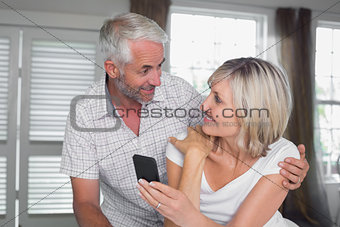 Couple looking at each other while reading text message