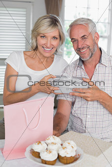 Mature man giving a gift box to happy woman