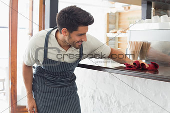 Waiter cleaning countertop with sponge